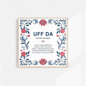 Könnte beinhalten: Ein gerahmter Druck mit weißem Hintergrund und einem blauen und roten floralen Rand. Der Text "UFF DA (oof-dah) Norwegian" befindet sich in der Mitte des Drucks. Der Text darunter definiert das Wort als "wird verwendet, um Verwirrung, Überraschung, Erleichterung, Erschöpfung, Enttäuschung oder Enttäuschung auszudrücken; oft ein Kennzeichen des skandinavischen Erbes. Z. B. "uff da, Lars hat meinen Lutefisk gegessen."