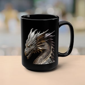 Op de afbeelding: Zwarte keramische mok met een zilveren en gouden drakenontwerp. De kop van de draak is naar de linkerkant van de mok gericht. De draak heeft een gedetailleerd ontwerp met schubben en stekels.