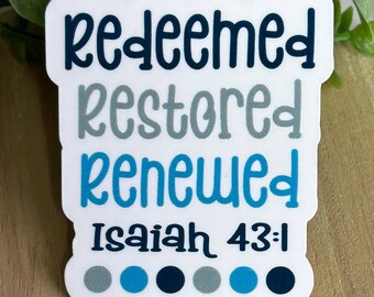 Può includere: Un adesivo bianco con bordo smerlato presenta le parole "redeemed, restored, renewed" in lettere blu e grigie. Il testo "Isaiah 43:1" è in basso. Sei punti colorati sono in basso, in tonalità di blu e grigio.