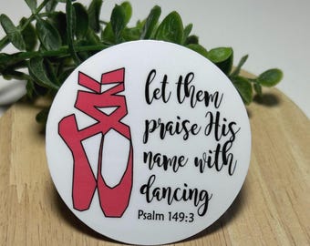 Może przedstawiać: Okrągła biała naklejka z grafiką różowych baletek z czarnymi konturami. Napis "let them praise His name with dancing" wykonano czarną czcionką imitującą pismo odręczne, a poniżej znajduje się mniejszy napis "Psalm 149:3".
