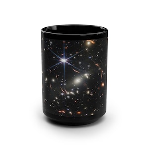 May include: Black ceramic mug with a colorful image of a galaxy with stars and nebulae.