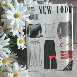May include: A white New Look sewing pattern envelope labeled 6838 with size range XS-XL. The front displays illustrations of three tops and two pairs of pants, including a striped long-sleeve shirt, a sleeveless top, and a long-sleeve V-neck shirt.
