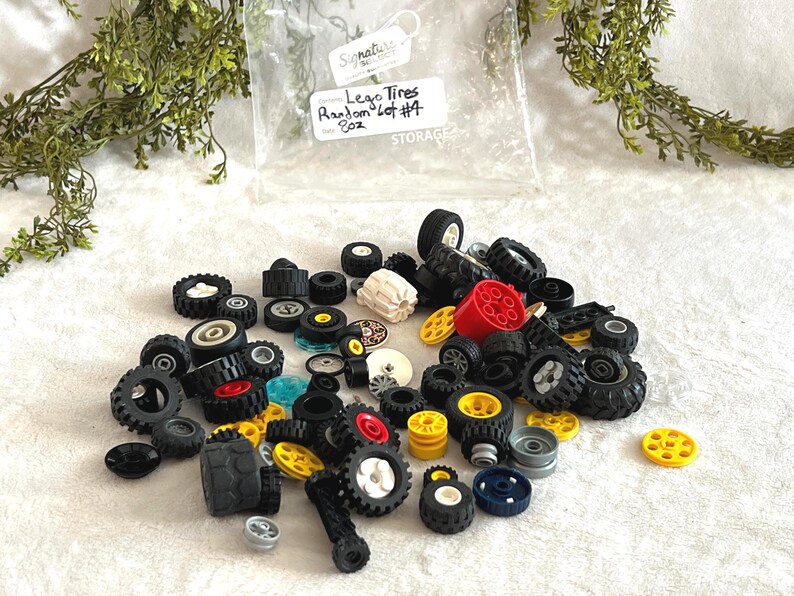 K&ouml;nnte beinhalten: Eine Sammlung verschiedener Lego-Reifen in verschiedenen Gr&ouml;&szlig;en und Farben, darunter Schwarz, Wei&szlig;, Rot und Gelb. Das Bild enth&auml;lt einen transparenten Plastikbeutel mit der Aufschrift "Lego Tires Random Lot #4 8oz."
