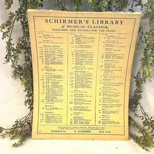 May include: A vintage sheet music book titled "Schirmer's Library of Musical Classics" with exercises and studies for the piano. The cover is yellowed with age and features a list of musical compositions and composers.
