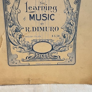 May include: Vintage sheet music cover with ornate blue and white design. The title reads "for Learning of Music" by R. DiMuro. The cover is aged with visible wear and tear, adding to its antique charm. The text "English-Italian" is also present.