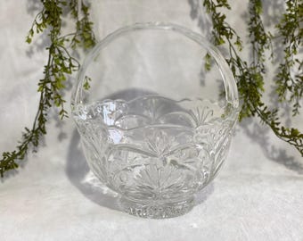 May include: A clear glass bowl with a decorative pattern and a handle. The bowl is made of crystal and has a classic design.