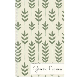May include: A spiral-bound notebook with a cream-colored background and a repeating pattern of green leaves. The words "Green Leaves" are written in a cursive font within a white rectangle at the bottom. The notebook has a silver spiral binding.