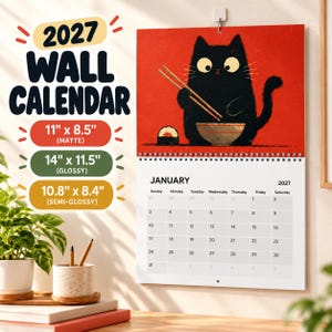 May include: A 2027 wall calendar featuring a black cat eating sushi with chopsticks on a red background. The calendar lists three available sizes: 11 inches by 8.5 inches matte, 14 inches by 11.5 inches glossy, and 10.8 inches by 8.4 inches semi-glossy.