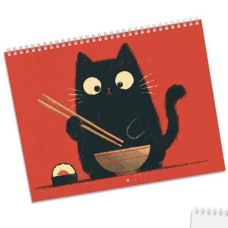 May include: A spiral-bound wall calendar featuring a graphic illustration of a black cat with large eyes holding wooden chopsticks over a bowl, with a piece of sushi nearby, all set against a solid, vibrant red background.