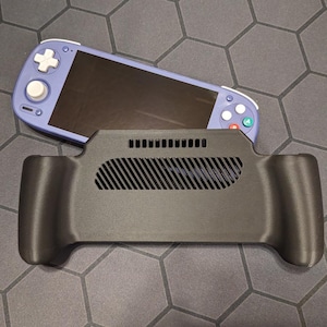 Op de afbeelding: Een zwarte gameconsole-grip met een ventilatieopening en een paars handheld gaming-apparaat. Het handheld-apparaat heeft een zwart scherm, witte knoppen en gekleurde bedieningsknoppen. De grip is ontworpen om het gamen te verbeteren.