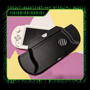 Könnte beinhalten: Eine weiße Handheld-Spielkonsole mit schwarzem Bildschirm und schwarzer Schutzhülle. Die Hülle ist schwarz mit einem kreisförmigen Lüfter und einem geschwungenen Design. Der Hintergrund ist eine Mischung aus Gelb, Lila und Weiß.