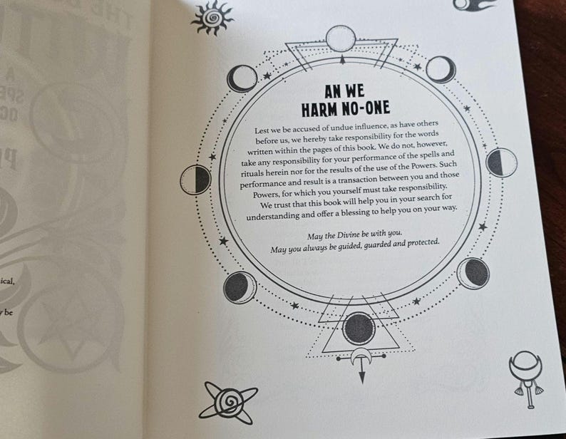 May include: An open book page with text and illustrations. The text "AN WE HARM NO-ONE" is within a circular design with moon phases, stars, and geometric shapes. The page is cream-coloured with black ink.