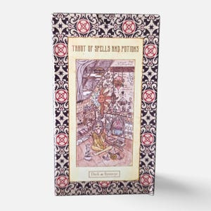 Könnte beinhalten: Eine rechteckige Schachtel für ein Tarot of Spells and Potions Deck. Der Rand zeigt ein verziertes schwarz-weißes Muster mit roten kreisförmigen Akzenten. Die zentrale Illustration zeigt eine Person, die in einem Raum mit Kamin sitzt.
