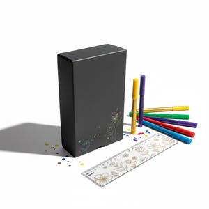 May include: A rectangular black box featuring a delicate white floral line drawing, accompanied by a set of six colorful felt-tip markers in yellow, purple, green, red, and blue, and a clear plastic ruler with a gold floral pattern.