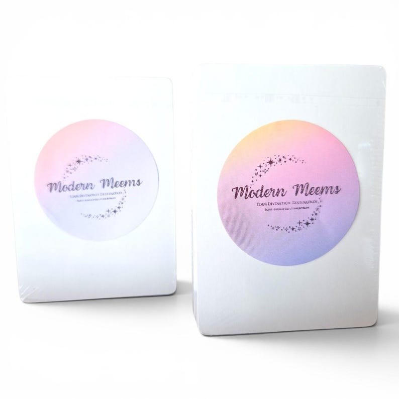 May include: Two rectangular white packages wrapped in clear plastic, each featuring a circular sticker with a pastel gradient background. The sticker displays the text Modern Meems and Your Destination Destination, accented by a crescent of small stars.