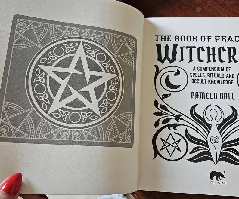 May include: An open book showing a gray and white pentagram design on the left page. The right page displays the title "The Book of Practical Witchcraft" with text: "A compendium of spells, rituals and occult knowledge" by Pamela Ball.