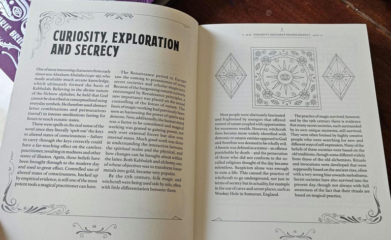 May include: An open book displaying the title "CURIOSITY, EXPLORATION AND SECRECY". The left page has text, the right page has illustrations of geometric shapes and symbols. The book's pages are cream-coloured, with black text.