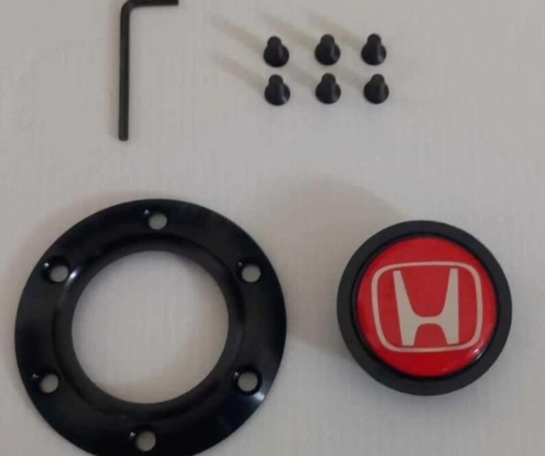 Pu&ograve; includere: Un kit adattatore per mozzo del volante nero con un emblema Honda rosso e bianco, sei viti nere e una chiave a brugola. Il kit include un anello circolare nero con sei fori.