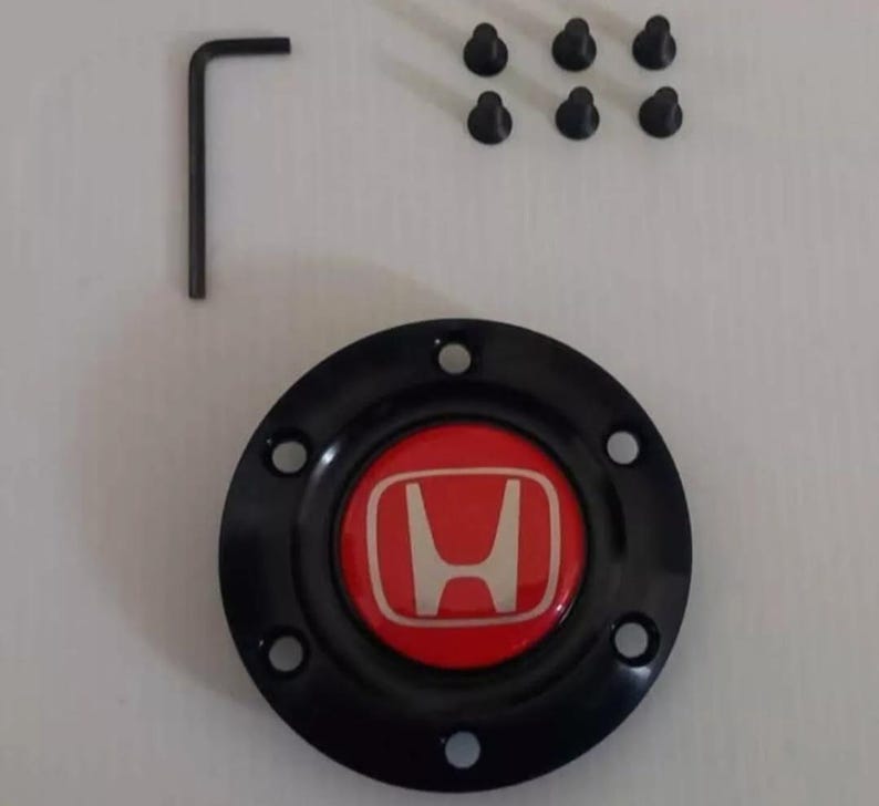 Pu&ograve; includere: Coprimozzo Honda nero e rosso con logo Honda argentato, sei viti nere e una chiave a brugola nera. Il coprimozzo &egrave; rotondo con sei fori sul perimetro.