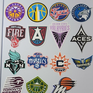 May include: A collection of colorful stickers featuring logos of various women's basketball teams. The stickers include team names like Sparks, Fever, Aces, and Wings, with designs incorporating team colors and imagery such as basketballs and flames.