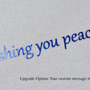 Closeup of an example of custom foil text in blue on metallic cardstock