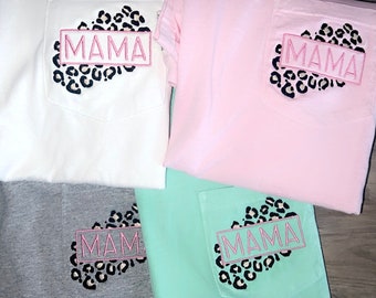 May include: Four t-shirts with a pocket on the front. Each pocket has a heart-shaped design with a leopard print and the word "MAMA" in a pink box.
