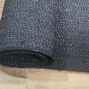 May include: A black rolled up mat with a textured surface.