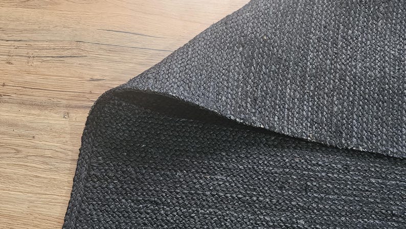 May include: Close-up of a black woven fabric with a textured surface.