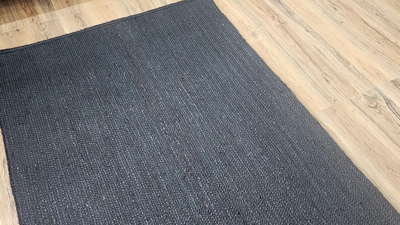 May include: A dark gray woven rug with a textured surface.