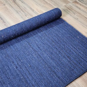May include: A rolled up blue jute rug with a woven texture.
