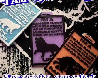 May include: Three rectangular plastic badges featuring animal silhouettes and text. The blue badge displays a cat, the purple badge shows a lion, and the orange badge depicts a raccoon. Each badge includes descriptive text like I'M A DANGER FLOOF and I'M A TRASH PANDA.