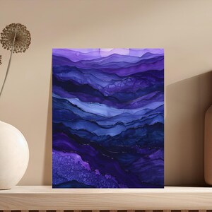 Abstract purple and blue flowing ink art with gold accents on a shelf.