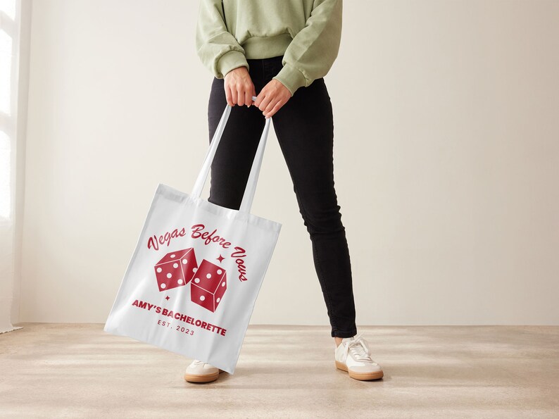 May include: White tote bag with red dice and the text "Vegas Before Vows" and "Amy's Bachelorette Est. 2023".