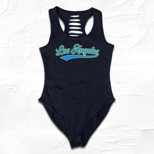 May include: Black bodysuit with a cutout back and a blue and yellow "Los Angeles" graphic on the front.