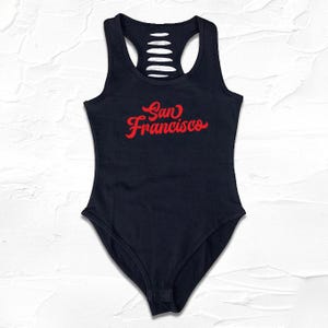May include: Black bodysuit with a cutout back and red "San Francisco" text.