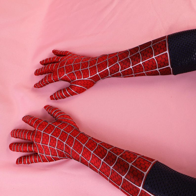 May include: A pair of long gloves featuring a vibrant red fabric base with a prominent silver web pattern covering the fingers and hands. The wrist area transitions into a solid black textured material, extending up the forearm for full coverage.
