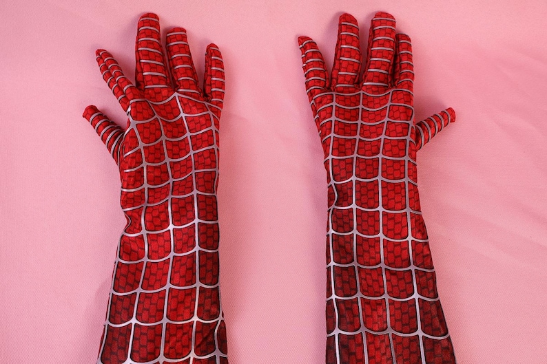 May include: A pair of long, red gloves featuring a printed silver web pattern that covers the entire surface. The gloves extend past the wrist and are designed with individual finger sections, showcasing a detailed grid-like texture throughout.