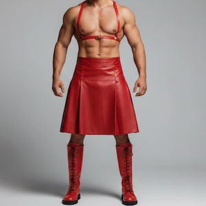 Peut inclure: Un kilt en cuir rouge avec un harnais en cuir rouge assorti et des bottes rouges à lacets. Le kilt a des plis et un ourlet droit. Les bottes montent jusqu'aux genoux et ont des semelles noires. Le harnais a une fermeture à boucle.