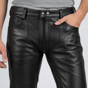 K&ouml;nnte beinhalten: Schwarze Lederhose mit Rei&szlig;verschluss, zwei Vordertaschen und G&uuml;rtelschlaufen. Die Hose hat ein klassisches F&uuml;nf-Taschen-Design mit sichtbaren Nahtdetails. Das Leder wirkt glatt und hat einen leichten Glanz.