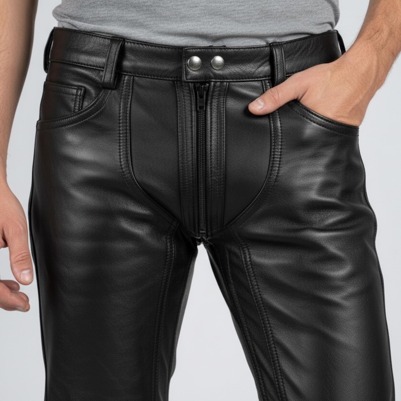 K&ouml;nnte beinhalten: Schwarze Lederhose mit Rei&szlig;verschluss, zwei Vordertaschen und G&uuml;rtelschlaufen. Die Hose hat ein klassisches F&uuml;nf-Taschen-Design mit sichtbaren Nahtdetails. Das Leder wirkt glatt und hat einen leichten Glanz.