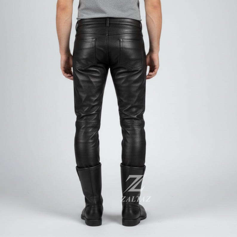 K&ouml;nnte beinhalten: Schwarze Lederhose mit klassischem F&uuml;nf-Taschen-Design. Die Hose wird mit schwarzen Lederstiefeln kombiniert. Die Stiefel haben ein Logo auf der Seite. Die Hose ist aus gl&auml;nzendem, glattem Leder gefertigt.