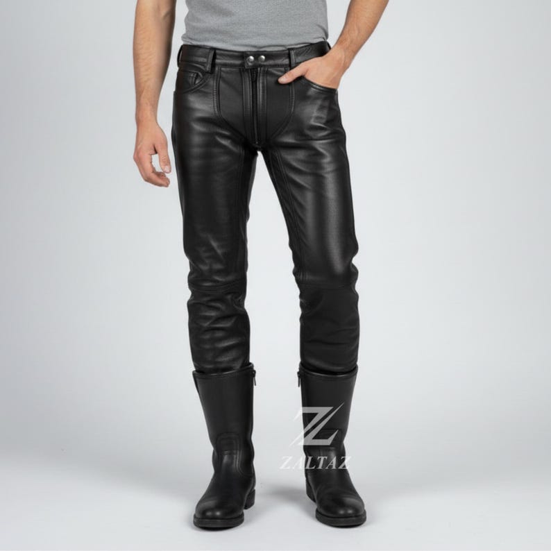 K&ouml;nnte beinhalten: Schwarze Lederhose mit Rei&szlig;verschluss und Taschen. Die Hose wird mit schwarzen Lederstiefeln getragen. Das Bild zeigt eine Person, die die Hose und die Stiefel tr&auml;gt. Die Hose hat ein klassisches, figurbetontes Design.