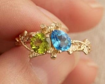 Ring met blauwe topaas en peridot, trouwring van sterling zilver met boomtakmotief, sieraden geïnspireerd op de natuur.