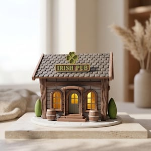 May include: A miniature Irish pub model with a brown, gray, and green color scheme. The model features a tiled roof, arched windows, and a door with the words "IRISH PUB" above it. Two small barrels and two green trees flank the building.