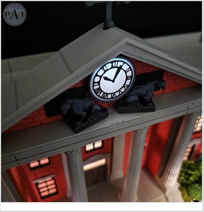 May include: A detailed model of a building with a clock tower. The clock face is illuminated, showing Roman numerals. The building has a red brick facade, white columns, and two black statues. The overall design is intricate and detailed.