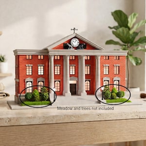May include: A miniature model of a red brick building with white columns and a clock tower. The model has multiple windows and a cross on top. Small green bushes and trees are in front of the building. The text "Meadow and trees not included" is visible.