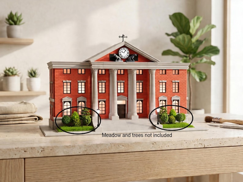 May include: A miniature model of a red brick building with white columns and a clock tower. The model has multiple windows and a cross on top. Small green bushes and trees are in front of the building. The text "Meadow and trees not included" is visible.