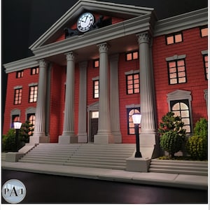 May include: A detailed model of a red brick building with white columns and a clock tower. The building has multiple windows with interior lighting, and is flanked by street lamps and greenery. The clock shows the time.