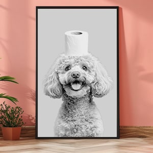 May include: A black and white framed wall art print featuring a fluffy poodle with a roll of white toilet paper balanced on its head. The dog has a happy expression with its mouth open and tongue visible, set against a solid light gray background.