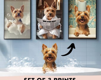May include: Set of three framed prints featuring Yorkshire Terriers in humorous bathroom scenes. One print shows a dog in a bubble bath, another reading "Dog News Daily," and the third with a toilet paper roll on its head. The prints are displayed against a blue tile background.